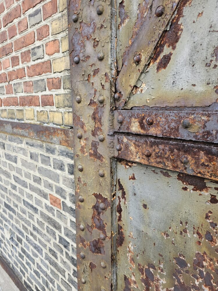 façade articulated by a steel column-and-beam grid with masonry infill, gevel met raster van stalen kolommen en balken met metselwerk als invulling (vakwerkgevel), historische staalskeletbouw 